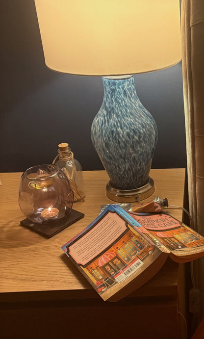 Elegant pearl grey glass wax melt burner glowing softly in a calm home setting.